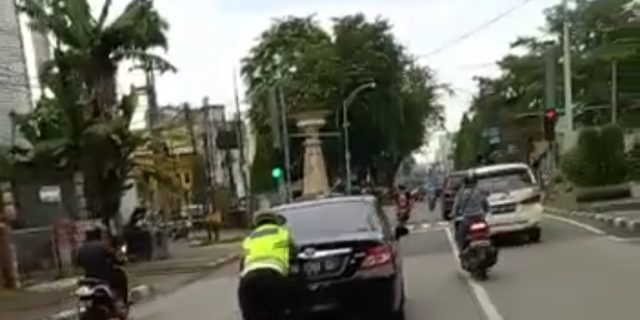 Personel Lantas Polsek Medan Kota Bantu Dorong Mobil Mogok